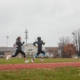 two females runners running fast on the track doing intervals in the rain.
