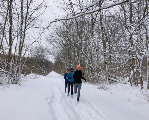 biking, snow running, and show drop with a photo of snowy path with three running bundled up running on the trail.